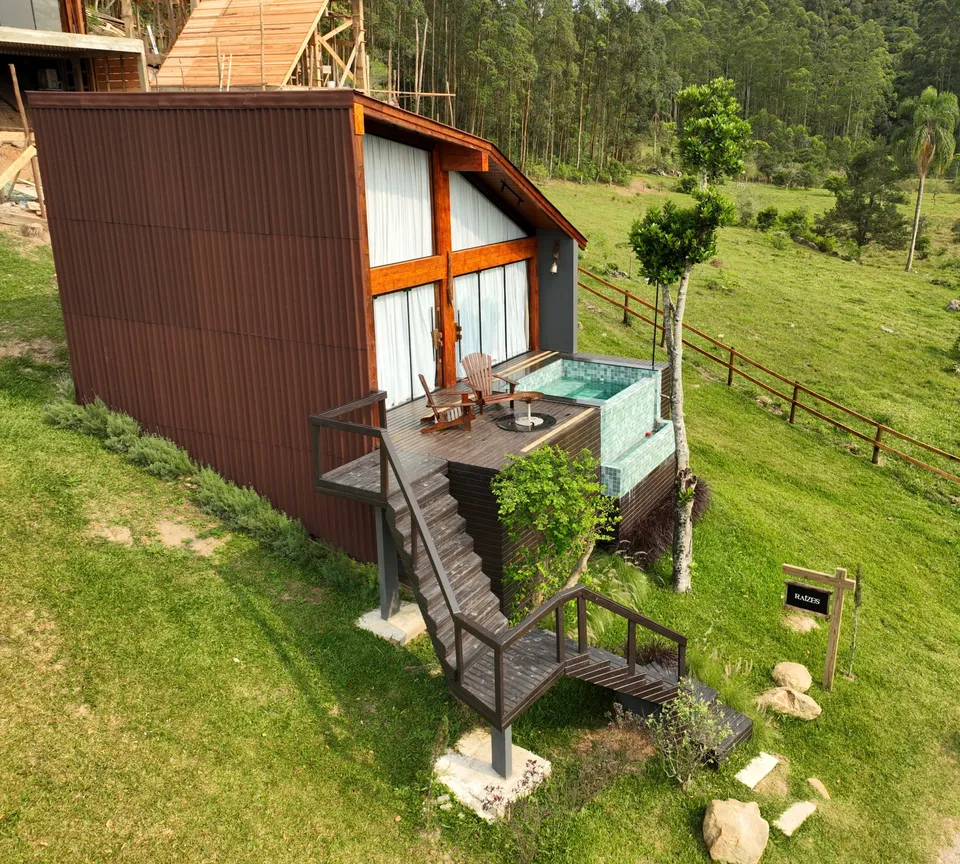 Cabana Raízes on the lawn, with the pool on the deck